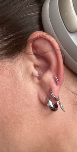 Customer's silver Amara Hoop Earrings worn in a multi-pierced ear stack.