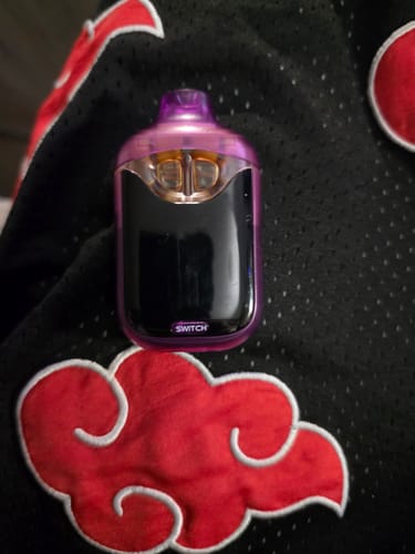 Customer's Switch 2G vape device in purple and black, resting on patterned fabric.