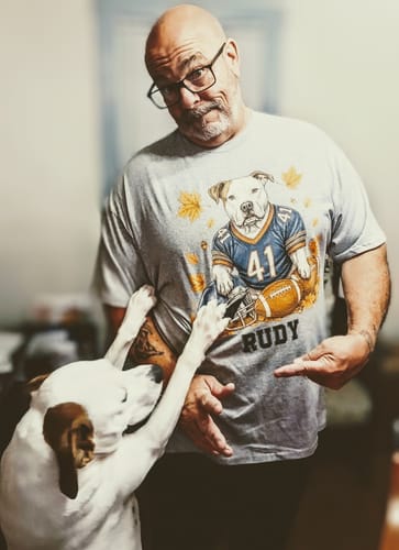 Customer's gray personalized shirt showing a dog printed in a football jersey, next to their real dog.