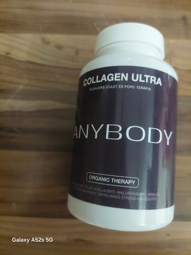 A vásárló fehér flakonos Anybody Collagen Ultra terméke egy fa asztalon.