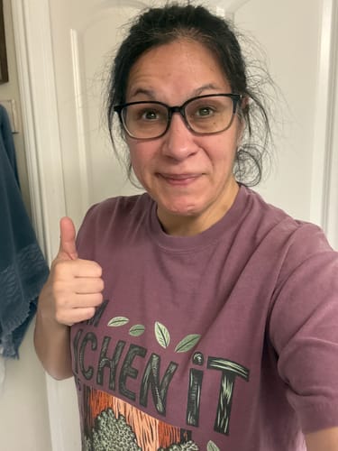 Reviewer gives a thumbs up while wearing the purple 'I'm Lichen It' T-shirt.