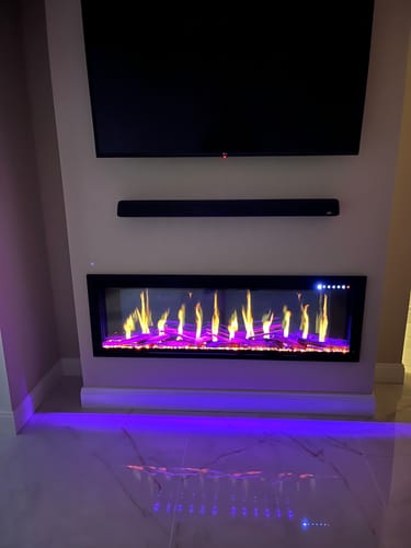 Customer's TruWood Logs Kit shown in a fireplace with vibrant yellow flames and a purple ember bed.