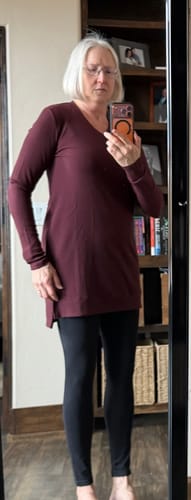 Reviewer wearing the garnet Evie Ribbed Tunic and black leggings, showing the front view and V-neck fit.