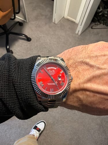Customer wearing their Lucky Fours® Santos watch, showing the red dial and silver link band on their wrist.