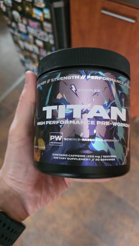 Customer holding a black tub of Titan High Performance Pre-workout.