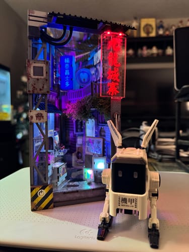 Reviewer's assembled Kowloon Walled City 2049 Book Nook Kit, showing a detailed cyberpunk alley lit up with red and blue neon signs.
