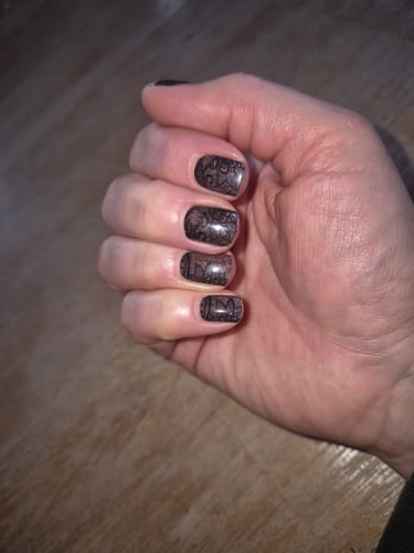 Kundenrezension: Hand mit 'Festive Lace' Nagelfolien. Ein filigranes Spitzenmuster auf glitzerndem Braun.