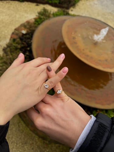 Reviewer shows two hands wearing matching gold Pia Rings on their pinky fingers.
