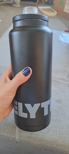 Reviewer holding the large, black Elyte Stainless Bottle with the lid removed.