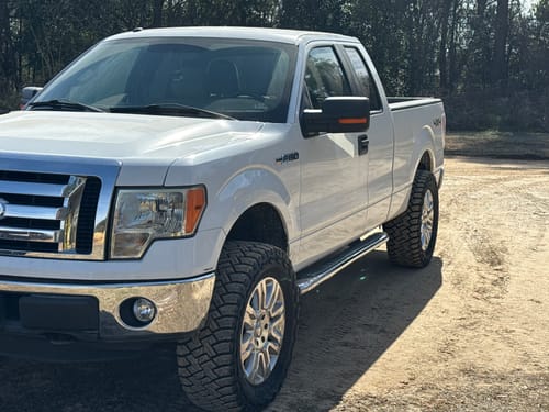Customer's white Ford F150 truck after installing the upper control arms and leveling kit, showing its lifted stance.