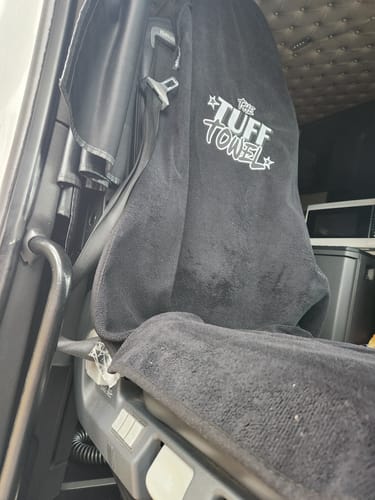 Customer's black towel seat cover with 'The Tuff Towel' logo installed in a vehicle.