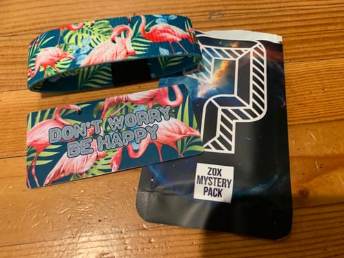 Customer's Mystery ZOX wristband with a tropical flamingo design, alongside its packaging and a matching collector's card.