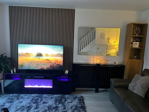 Customer's living room with Acoustic Wall Panel End Trims finishing a dark slat panel feature wall behind a TV.