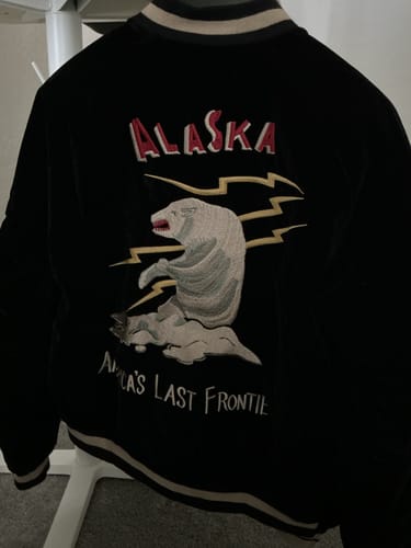 Reviewer's black Alaska Souvenir Jacket showing the detailed polar bear and 'Alaska' embroidery on the back.