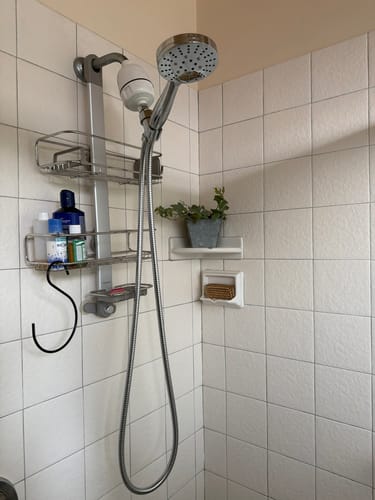 Customer's 3-Spray Handheld Shower Head Set installed in a tiled shower, highlighting the long, flexible metal hose.
