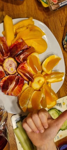 Kunde zeigt das Ergebnis der Verkostung: saftige, aufgeschnittene Washington Navel Orangen mit Daumen hoch.