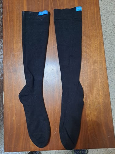 Reviewer's pair of black Performance Eucalyptus Compression Socks laid flat on a wooden surface.