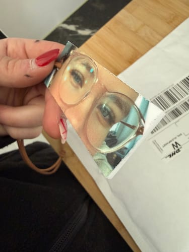 Ein Kunde hält den Rückspiegel-Anhänger mit Augenmotiv in der Hand.