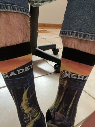 Customer wearing the Megadeth 'Killing Is My Business' album art socks with blue jeans while sitting in a chair.