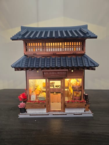 A customer's assembled Ikseon-dong Hanok Bakery miniature kit, with its warm interior lights turned on.