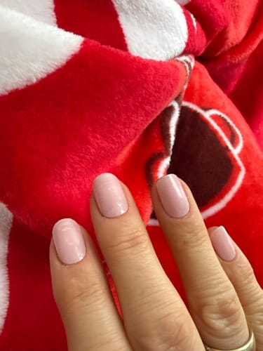 Kundin zeigt ihre Nägel mit den semitransparenten UV Gel Nail Wraps in Rosé Teint.
