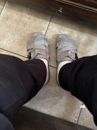 Customer's point-of-view wearing the grey Reflective Dracoslides with white socks indoors on a tiled floor.
