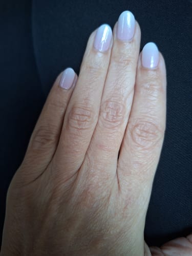 Eine Kundin zeigt ihre manikürten Nägel mit dem schönen Babyboomer Lilac Farbverlauf.