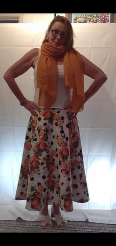 Customer wearing a full A-line skirt made from the Orange Punch Scuba Fabric, showing the cheerful orange print.
