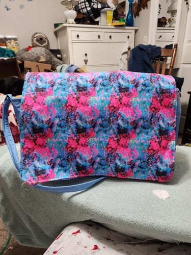 Customer's finished purse made with the vibrant Funky Ink #8 Fabric, sitting on a bed.