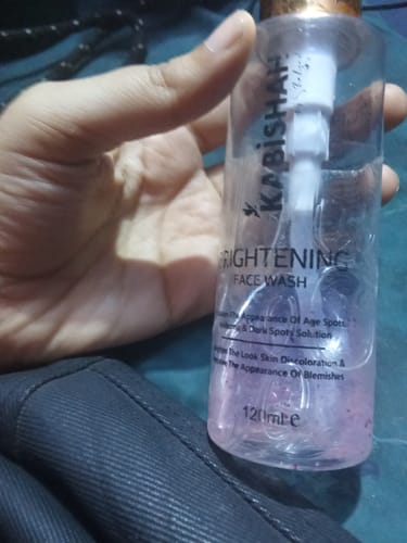 Close-up of a reviewer's hand holding the Kabishah Brightening Face Wash in a clear pump bottle.
