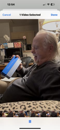 Customer smiling while holding the blue and white packaging for the Weekly AM-PM Vitamin Case 2.0.