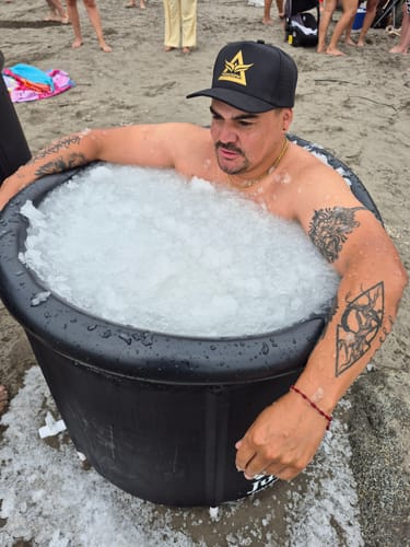 Cliente usando su Cadena Rope Oro 4mm mientras está en un baño de hielo en la playa.