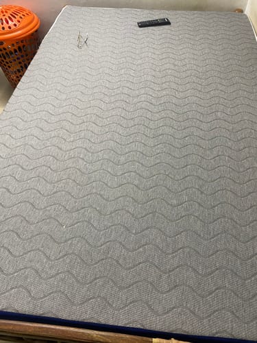 Customer's close-up of the grey, wavy-patterned Flo Mattress Ortho on a bed frame.