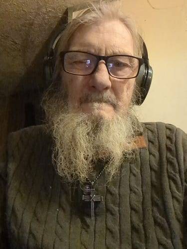 Reviewer wearing the Nailed to the Cross necklace against a green cable-knit sweater.