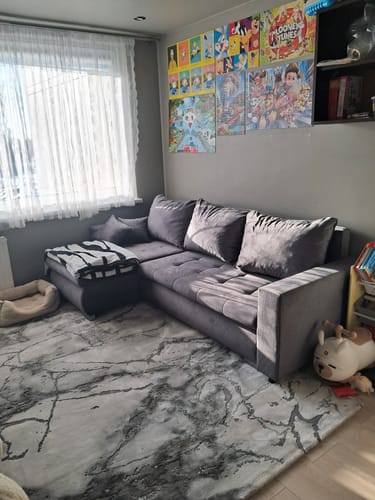 Kliento pilka kampinė sofa „Baldo užnešimas“ svetainėje.