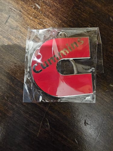 Reviewer shows a prize won from the Quick Entry: a red, C-shaped keychain in its wrapper.