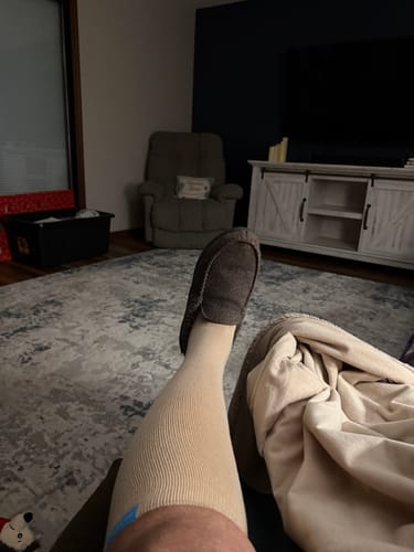 Customer wearing the beige Performance Eucalyptus Compression Socks while relaxing at home.