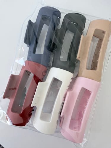 Reviewer's new Mello hair clips in various solid colors, sealed in a clear package.