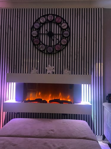 Customer's black and white acoustic slatted panels used as a stylish feature wall behind an electric fireplace.