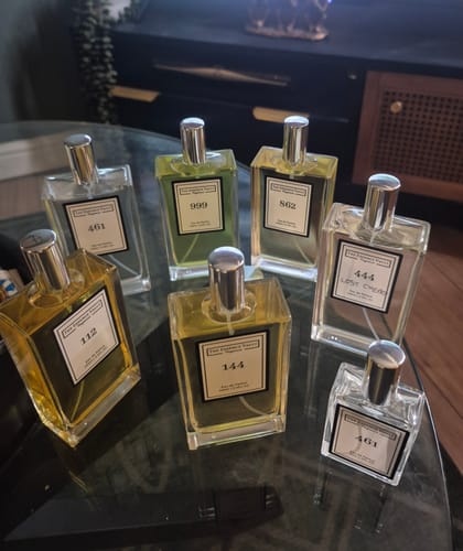 Customer's No. 144 perfume bottle displayed on a glass table with several other fragrances from their collection.