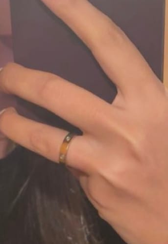 Nahaufnahme: Eine Kundin trägt den goldenen Arianna Ring mit Zirkonia-Steinen am Finger.
