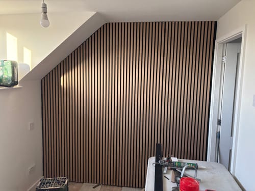 Customer's acoustic slatted wall panels installed on a feature wall, cut to fit under a sloped ceiling.
