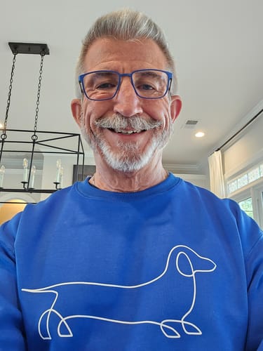Reviewer smiling while wearing the bright blue Line Dachshund Print Relax Fit Sweatshirt.