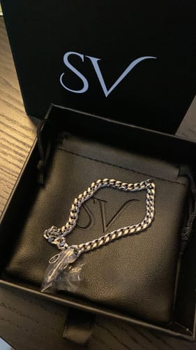El cliente muestra la Pulsera Miami Cuban 5mm en su caja negra original sobre un estuche.