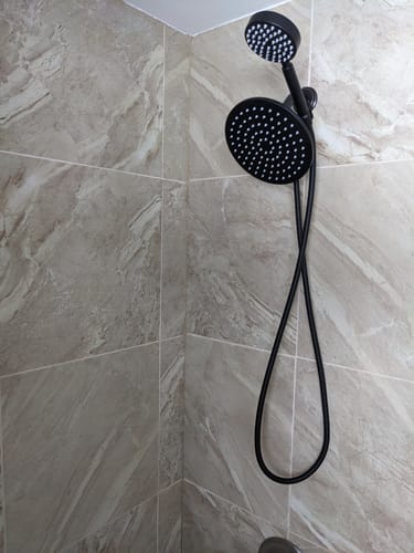 Customer's black 1-Spray Dual Shower Head Set installed in a tiled shower.