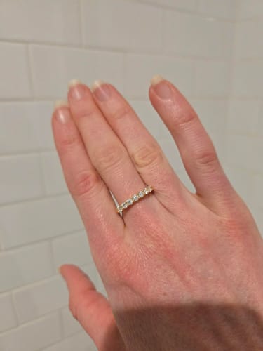 Reviewer wearing the 3mm Moissanite Half Eternity Ring on their hand against a white tile background.