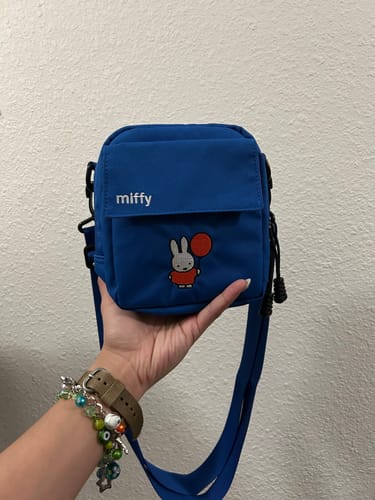 Customer holding the blue Miffy Instant Camera Bag in their hand, showing its size and front graphic.