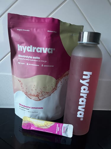 Reviewer's hydrava electrolyte salts pouch, a single sachet, and the mixed Strawberry Lemonade drink in a branded bottle.