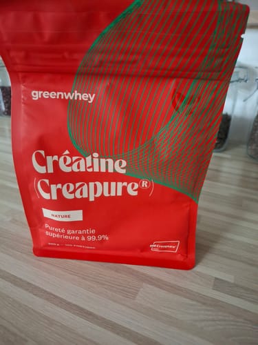 Le sachet rouge de Créatine Creapure® d'un client, posé sur une surface en bois.