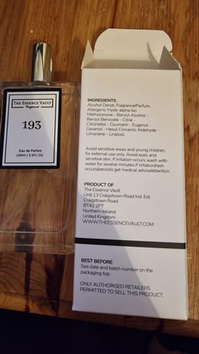 Reviewer's bottle of Inspired By Bianco Latte - 193 perfume next to its open white packaging box on a wooden surface.